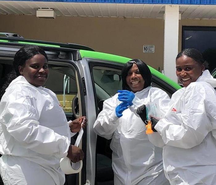 three women dressed in PPE suits
